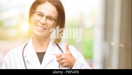 Arzt Frau, Arzt lächelte breit, Daumen oben-Geste auf Kamera, Ausdruck des Wie und Genehmigung Stockfoto