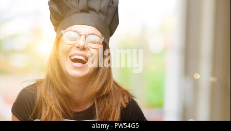 Mittleres Alter Koch Frau Koch Schürze zuversichtlich und zufrieden mit einen großen natürlichen Lächeln Lachen Stockfoto