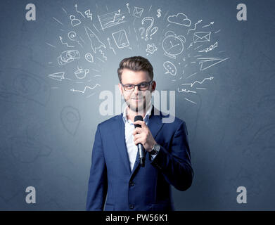 Geschäftsmann sprechen in das Mikrofon mit gemischten Doodles über seinem Kopf Stockfoto