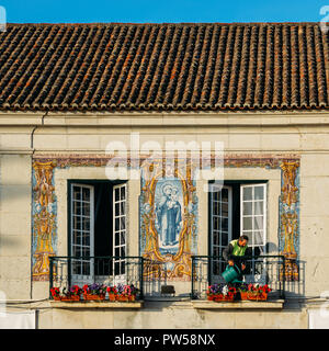 Cascais, Portugal - May 12, 2018: Ein Mann Wasser Pflanzen auf dem Balkon von Cascais Rathaus mit schönen Azulejos portugiesischen Kacheln dekoriert Stockfoto