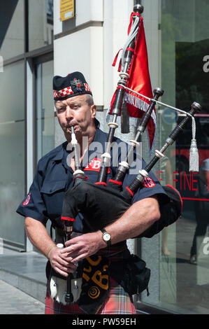 LONDON, Großbritannien - 18.JULI: ein Feuerwehrmann der Feuerwehr spielt eine traditionelle Dudelsack in London am 18. Juli 2013. Stockfoto