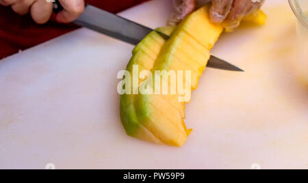 Die Hand der Frau ist die Melone für Salat und zum Verkauf in Reisenden. Stockfoto