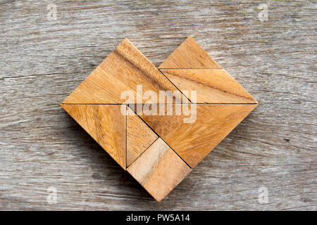 Tangram-Puzzle in Herzform auf hölzernen Hintergrund Stockfoto