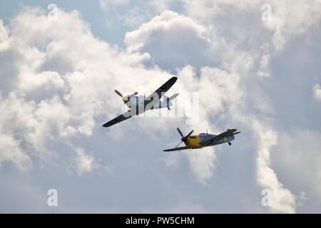 Paar Hispano HA-1112 M4L Buchons (Messerschmitt Bf109) fliegen am IWM Duxford Schlacht von Großbritannien Airshow am 23. September 2018 Stockfoto