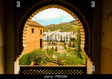 Blick aus dem Fenster mit Blick auf die Downtown von der Stadt Granada. Arch Windows arabischer Herkunft und Stadt Architektur von arabischen Einfluss. Mauren. Stockfoto