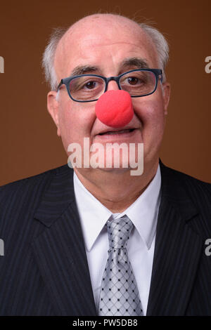 Übergewicht älterer Geschäftsmann das Tragen der roten Clownnase Stockfoto