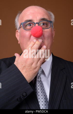 Übergewicht älterer Geschäftsmann das Tragen der roten Clownnase Stockfoto