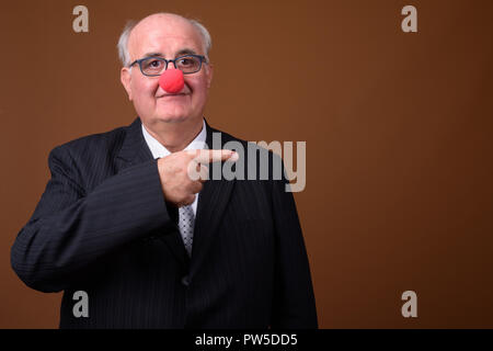 Übergewicht älterer Geschäftsmann das Tragen der roten Clownnase Stockfoto