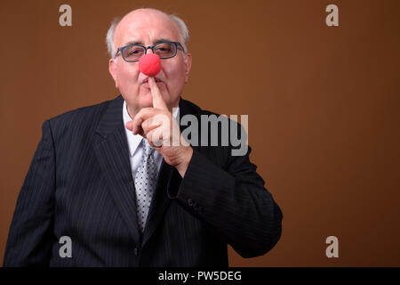 Übergewicht älterer Geschäftsmann das Tragen der roten Clownnase Stockfoto