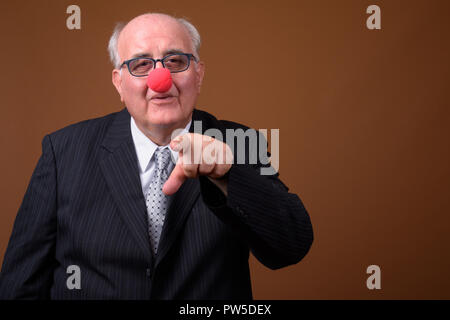 Übergewicht älterer Geschäftsmann das Tragen der roten Clownnase Stockfoto