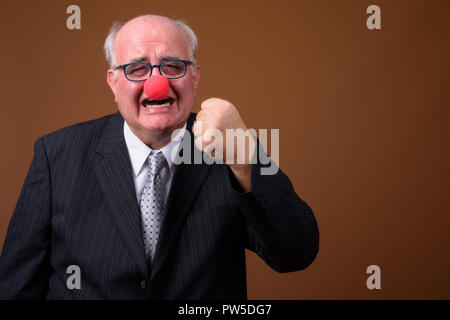 Übergewicht älterer Geschäftsmann das Tragen der roten Clownnase Stockfoto