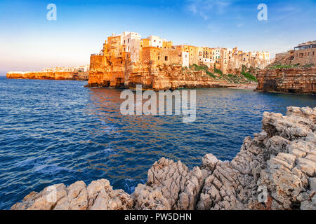 Polignano a Mare, Apulien, Italien: Sonnenuntergang in Cala Paura Golf mit Bastione di Santo Stefano und Lama Monachile Strand im Hintergrund, Apulien, Italien, provi Stockfoto