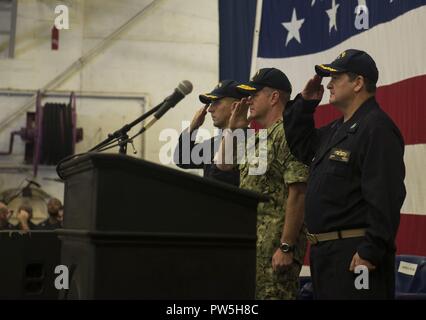 Atlantischer Ozean (Sept. 19, 2017) Leutnant Paul Tremblay, Kaplan, links, hinten Adm. Samuel Paparo, Commander, Carrier Strike Group (CSG) 10, und Kapitän James R. Midkiff, kommandierender Offizier der Amphibisches Schiff USS Iwo Jima (LHD7), Salute für das Singen der Nationalhymne im Hangar Bay bei einem Befehl Zeremonie. Während der Zeremonie, Kapitän Joseph R. O'Brien entlastet Midkiff 12 Iwo Jima der kommandierende Offizier zu werden. Stockfoto