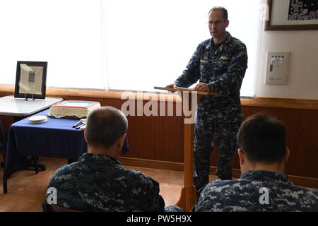 SASEBO, Japan (Sept. 19, 2017) Kaplan lt Byron Johnson, Commander, US-Flotte Aktivitäten Sasebo zugeordnet, spricht an der KFBS POW/MIA Gedenkfeier Sept. 19, 2017. Johnson holte eine gestaltete Zeitung Artikel über seinen Großvater und teilte seine Geschichte als Kriegsgefangener während des Zweiten Weltkriegs. Stockfoto