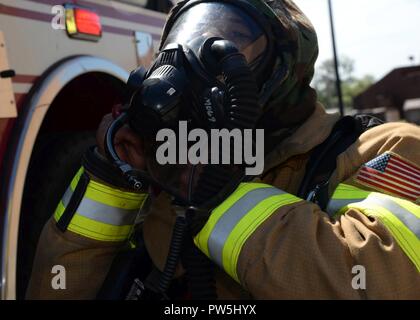 Airman Marcus Grau, 51. Bauingenieur Squadron Feuerwehrmann, zieht seine Gasmaske, um vor der Beantwortung zu einem simulierten Brand während der Übung Beverly Herde 17-3 am Osan Flughafen, Republik Korea September 20, 2017. Die Übung wurde gehalten, um zu bewerten, wie gut die Basiseinheiten Emergency Support während der Verteidigung Assets und Personal in einer feindlichen chemischen, biologischen, radiologischen und nuklearen Umgebung bereitgestellt. Stockfoto