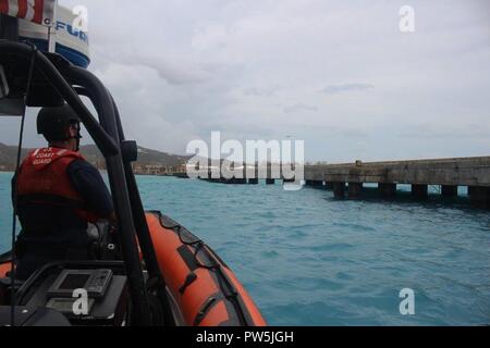 Petty Officer 1st Class Don Ellison, ein boatswains Mate an Bord der Coast Guard Cutter Valiant, bewertet pier Schäden in Frederiksted, St. Croix, nach dem Hurrikan Maria, Sept. 21, 2017. Die Hauptaufgabe der Crew der Valiant ist Suche und Rettung zu leiten, aber auch Port Bewertungen durchführen, liefern Hilfsgüter und helfen, das in der Gegend. Stockfoto