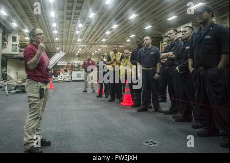 5. Flotte BEREICH VON OPERATIONEN (Sept. 20, 2017) Chief's Gunner Mate Alishia Prescott, ein Eingeborener von Peabody, Massachusetts, zu den Waffen Abteilung zugewiesen an Bord der Amphibisches Schiff USS America (LHA 6), Slips Matrosen vor Erleichterung einer Live Fire Übung im Hangar Bay. Amerika ist das Flaggschiff der Amerika amphibische Gruppe und bereit, mit der begonnen 15 Marine Expeditionary Unit, ist zur Unterstützung der Maritime Security Operations und Theater Sicherheit Zusammenarbeit in den USA 5 Flotte Bereich der Operationen eingesetzt. Stockfoto