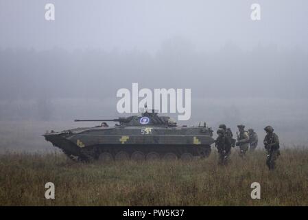 Ukrainische Armee Soldaten aus dem ersten Bataillon, 30 mechanisierte Brigade Vorauszahlung gegen feindliche Rolle Spieler während der Übung Rapid Trident 2017 Sie yavoriv Combat Training Center auf dem internationalen Friedens und der Sicherheit in der westlichen Ukraine, Sept. 21. Schnelle Trident ist eine jährliche, multinationale Übung mit rund 2 000 Mitarbeitern aus 14 Nationen. Die Übung besteht aus einer multinationalen Brigade, computergestützte Kommandostellenübung mit einem Bataillon-level Feld Training und platoon-situative Übungen integriert. Die Ex Stockfoto