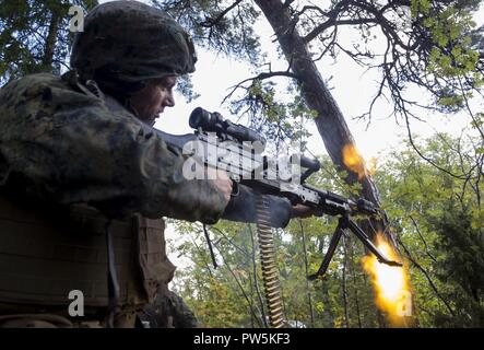 Ein US-Marine mit Marine Rotational Force-Europe bietet Abdeckung Feuer für seine Gruppe während der Übung Aurora 17 in Lärbro, Schweden, Sept. 21, 2017. Aurora 17 ist die grösste Schwedische Nationale Übung in mehr als 20 Jahre, und es umfasst unterstützende Kräfte aus den USA und anderen Nationen, um Schwedens Verteidigung Fähigkeit zur Ausübung und gemeinsame regionale Sicherheit zu fördern. Stockfoto