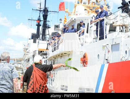 Leighton Tseu, Kane O Ke Kai, gibt einen Hawaiianischen Segen bei der Ankunft der Coast Guard Cutter Oliver Berry (WPC 1124) bei Coast Guard Base Honolulu, Sept. 22, 2017. Die Oliver Berry ist die erste von drei 154-Fuß-schnelle Reaktion Fräser in Hawaii stationiert. Stockfoto