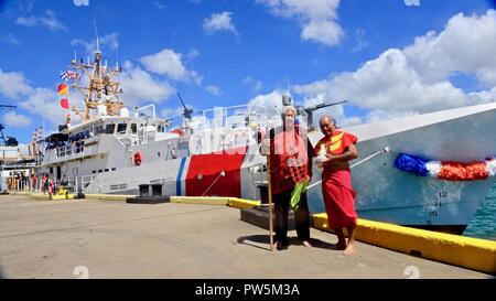 Leighton Tseu, Kane o ke Kai, und Richard 'Baby' Bell, Pu-Kane, stehen für ein Foto nach Segen Coast Guard Cutter Oliver Berry (WPC 1124) Nach Ihrer Ankunft in Honolulu Sept. 22, 2017. Dies ist der erste von drei schnelle Reaktion Fräser nach Hawaii zu kommen. Stockfoto