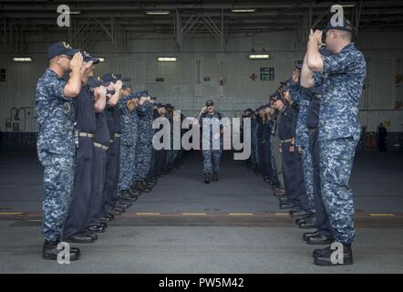 NORFOLK, Virginia (Sept. 22, 2017) Senior Chief's Machinist Mate (nuklearen) Justin Hensley kehrt die begrüßt der USS Gerald R. Ford (CVN 78) Segler, als er das Schiff fährt. Stockfoto