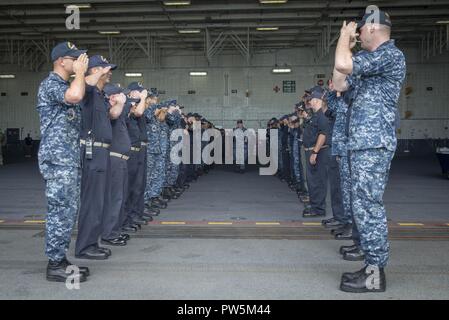 NORFOLK, Virginia (Sept. 22, 2017) Leutnant Nikolaus Rimes liefert die begrüßt der USS Gerald R. Ford (CVN 78) Segler, als er das Schiff fährt. Stockfoto