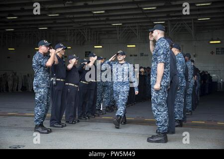 NORFOLK, Virginia (Sept. 22, 2017) Hospital Corpsman 3. Klasse Timothy McBride liefert die begrüßt der USS Gerald R. Ford (CVN 78) Segler, als er das Schiff fährt. Stockfoto