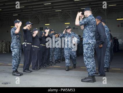 NORFOLK, Virginia (Sept. 22, 2017) Leutnant Nikolaus Rimes liefert die begrüßt der USS Gerald R. Ford (CVN 78) Segler, als er das Schiff fährt. Stockfoto