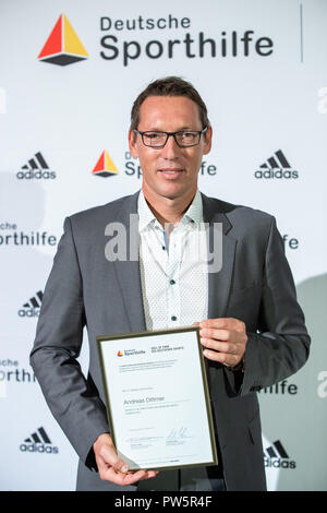 12 Oktober 2018, Bayern, Herzogenaurach, 12. Oktober 2018, Deutschland, Herzogenaurach: Andreas Dittmer, Olympischen Kanu Meister, steht vor einem Logo an der Wand mit seinem Zertifikat während der Zeremonie in der "Hall of Fame des deutschen Sports" der Stiftung Deutsche Sporthilfe. Der Athlet wurde offiziell in die "Hall of Fame des deutschen Sports" akzeptiert. Foto: Daniel Karmann/dpa Stockfoto