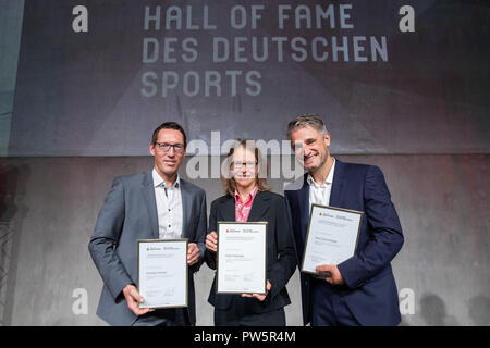 12 Oktober 2018, Bayern, Herzogenaurach, 12. Oktober 2018, Deutschland, Herzogenaurach: Andreas Dittmer (L), Olympischen Kanu Meister Katja Seizinger Weber, ehemaliger Skifahrer und Olympiasieger und Gerd Schoenfelder, ehemalige alpine Ski Racer und Paralympics Sieger, Seite an Seite mit ihren Zertifikaten während der Zeremonie der Aufnahme in die "Hall of Fame des deutschen Sports" der Stiftung Deutsche Sporthilfe. Die drei Athleten wurden offiziell in die "Hall of Fame des deutschen Sports" aufgenommen. Foto: Daniel Karmann/dpa Stockfoto