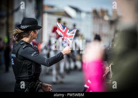 Windsor, Großbritannien. 12. Oktober, 2018. Eine Polizistin Wellen eine union flag Während der königlichen Hochzeit von Prinzessin Eugenie & Jack Brooksbank in Windsor Credit: IAN SKELTON/Alamy leben Nachrichten Stockfoto