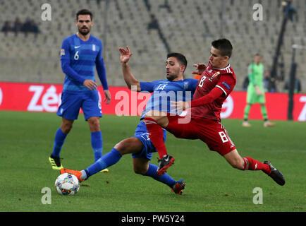 Athen, Griechenland. 12 Okt, 2018. Tasos Bakasetas (C) der Griechenland Mias mit Ungarns Adam Nagy (R) während der Liga C Gruppenspiel der UEFA Nationen Liga in Athen, Griechenland, Oktober 12, 2018. Griechenland gewann 1:0. Credit: Marios Lolos/Xinhua/Alamy leben Nachrichten Stockfoto