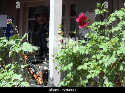 Srinagar, Kashmir. 13. Oktober, 2018. Eine Indische trooper Enge vigil Innenseite Wahllokal während. J&K städtischen lokalen Körper Umfragen Abstimmungen in der dritten Phase in 13 Jahren. Kaschmir unter fester Sicherheit und einer separatistischen gesponserten herunterfahren. Behörden bereitgestellt werden Zehntausende zusätzliche Soldaten in den bereits hoch militarisierten Region für die Wahlen, die in vier Phasen festgehalten werden. Am Samstag Morgen in muslimisch dominierten Gebieten Tal. eine Ausgangssperre war in der Tat in Teilen der Stadt Srinagar anti-Indien Proteste zu verhindern. © sofi Suhail/Alamy leben Nachrichten Stockfoto