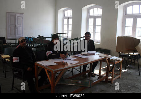 Srinagar, Kashmir. 13. Oktober, 2018. Kaschmir poling Offiziere in ein leeres poling Station bei J&K städtischen lokalen Körper Umfragen Abstimmungen sind in der dritten Phase gesehen, während in 13 Jahren. Kaschmir unter fester Sicherheit und einer separatistischen gesponserten herunterfahren. Behörden Zehntausende zusätzliche Soldaten in den bereits hoch militarisierten Region für die Wahlen, die in vier Phasen durchgeführt werden bereitgestellt. am Montag morgen in muslimisch dominierten Gebieten Tal. eine Ausgangssperre war in der Tat im alten Teil der Stadt von Srinagar anti-Indien Proteste zu verhindern. © sofi Suhail/Alamy leben Nachrichten Stockfoto