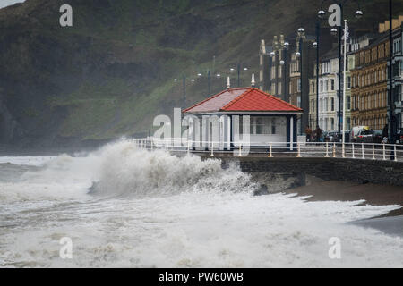 Aberystwyth Wales UK. 13. Oktober, 2018. UK Wetter: High tide am 11 bin und mit wehenden Winde auf 50 mph und mehr, am Ende des Sturms Callum hat immer noch genug Energie, um riesige Wellen zu bringen Absturz in die direkt am Meer und der Promenade in Aberystwyth auf der Cardigan Bay Küste von West Wales Photo Credit: Keith Morris/Allamy leben Nachrichten Stockfoto