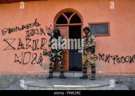 Srinagar, Kashmir. 13. Oktober 2018. Paramilitärische troopers stand Guard außerhalb der Wahllokale in der dritten Phase der Kommunalwahlen in SrinagarKashmir. Die dritte Phase des Jammu und Kaschmir städtischen lokalen Körper begann in 300 Wahllokalen bei 6 am Samstag unter strengen Sicherheitsmaßnahmen bin. Mehr als 365 Kandidaten sind in den Kampf für die Wahlen. Credit: SOPA Images Limited/Alamy leben Nachrichten Stockfoto