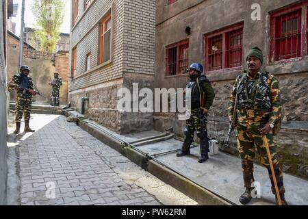 Srinagar, Kashmir. 13. Oktober 2018. Paramilitärische troopers stand Guard außerhalb der Wahllokale in der dritten Phase der Kommunalwahlen in SrinagarKashmir. Die dritte Phase des Jammu und Kaschmir städtischen lokalen Körper begann in 300 Wahllokalen bei 6 am Samstag unter strengen Sicherheitsmaßnahmen bin. Mehr als 365 Kandidaten sind in den Kampf für die Wahlen. Credit: SOPA Images Limited/Alamy leben Nachrichten Stockfoto