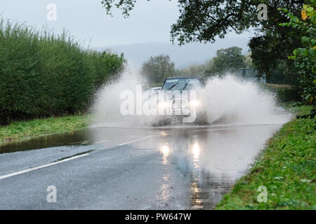 Brede, Powys, Wales - Am Samstag, den 13. Oktober 2018 - Ein 4WD Auto fährt durch Überschwemmungen auf der Straße bei Crickhowell nach sintflutartigen Regenfällen während Sturm Callum - der angrenzenden Fluss Usk hat die Ufer. Foto Steven Mai/Alamy leben Nachrichten Stockfoto