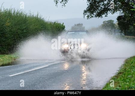 Brede, Powys, Wales - Am Samstag, den 13. Oktober 2018 - Ein 4WD Auto fährt durch Überschwemmungen auf der Straße bei Crickhowell nach sintflutartigen Regenfällen während Sturm Callum - der angrenzenden Fluss Usk hat die Ufer. Foto Steven Mai/Alamy leben Nachrichten Stockfoto