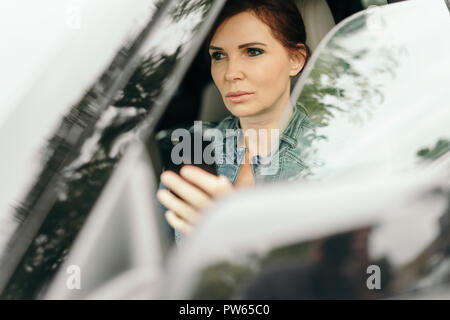 Geschäftsfrau sms während der Fahrt im Auto zu arbeiten Stockfoto