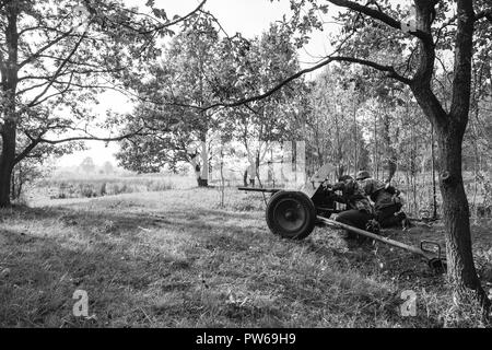 Re-enactment verkleidet als deutsche Wehrmacht Infanterie Soldat im zweiten Weltkrieg versteckt sitzen mit deutschen Panzerabwehrkanone Kanone Waffe In einem Hinterhalt In Graben Stockfoto