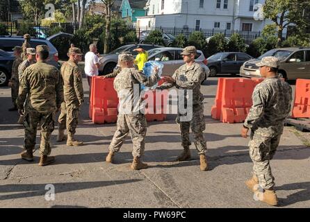 Armee SPC. Kevin Dulinawka, Mitte, hilft Pass gespendet wurden Fälle von Wasser an einem New York National Guard spende Sammelstelle an der Connecticut Straße Waffenkammer in Buffalo, New York, Dulinawka, zusammen mit anderen Soldaten der 27. Feuerwehr spezielle Truppen Bataillon, geholfen, Spenden für Puerto Rico und den U.S. Virgin Islands als Teil des New Yorker Unterstützung für Wiederherstellungsmaßnahmen nach Hurrikane Irma und Maria sammeln. Die New York National Guard verfügt über mehr als 700 Soldaten und Piloten Unterstützung Wiederaufnahme Bemühungen, von uns eingesetzten Flugzeuge und Personal zur Unterstützung 14 Spendezentren über New Yo Stockfoto