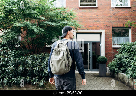 Ein Tourist geht in die Pension oder Herberge, um in ein Zimmer, dass er gebucht oder ein Student mit einem Rucksack kehrt nach seinem Studium am Institut oder auf Urlaub. Stockfoto