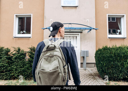 Ein Tourist geht in die Pension oder Herberge, um in ein Zimmer, dass er gebucht oder ein Student mit einem Rucksack kehrt nach seinem Studium am Institut oder auf Urlaub. Stockfoto