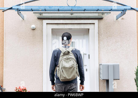 Ein Tourist geht in die Pension oder Herberge, um in ein Zimmer, dass er gebucht oder ein Student mit einem Rucksack kehrt nach seinem Studium am Institut oder auf Urlaub. Stockfoto