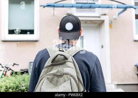 Ein Tourist geht in die Pension oder Herberge, um in ein Zimmer, dass er gebucht oder ein Student mit einem Rucksack kehrt nach seinem Studium am Institut oder auf Urlaub. Stockfoto