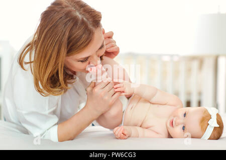 Eine glückliche Großmutter mit Baby Enkel auf dem Bett. Stockfoto