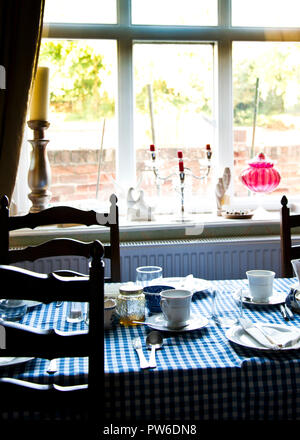 Traditionelle englische Frühstückstisch gegen Fenster, Interieur des alten Cottage Gästehaus.England, Großbritannien. Stockfoto