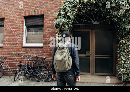 Ein Tourist geht in die Pension oder Herberge, um in ein Zimmer, dass er gebucht oder ein Student mit einem Rucksack kehrt nach seinem Studium am Institut oder auf Urlaub. Stockfoto